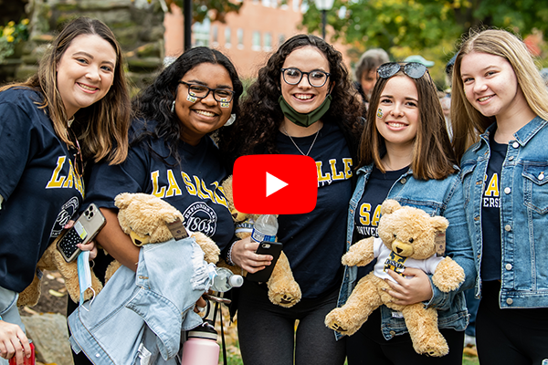 Five students wearing La Salle t-shirts and holding La Salle bears posing for a photo.