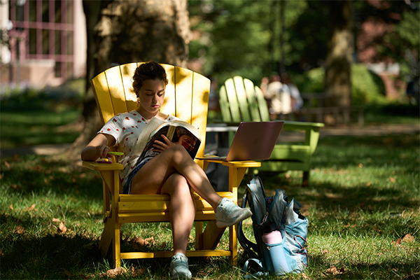 Image of a student reading on the Hansen Quad. 
