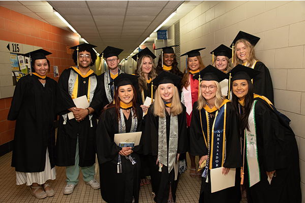 Image of graduates posing for a photo indoors.