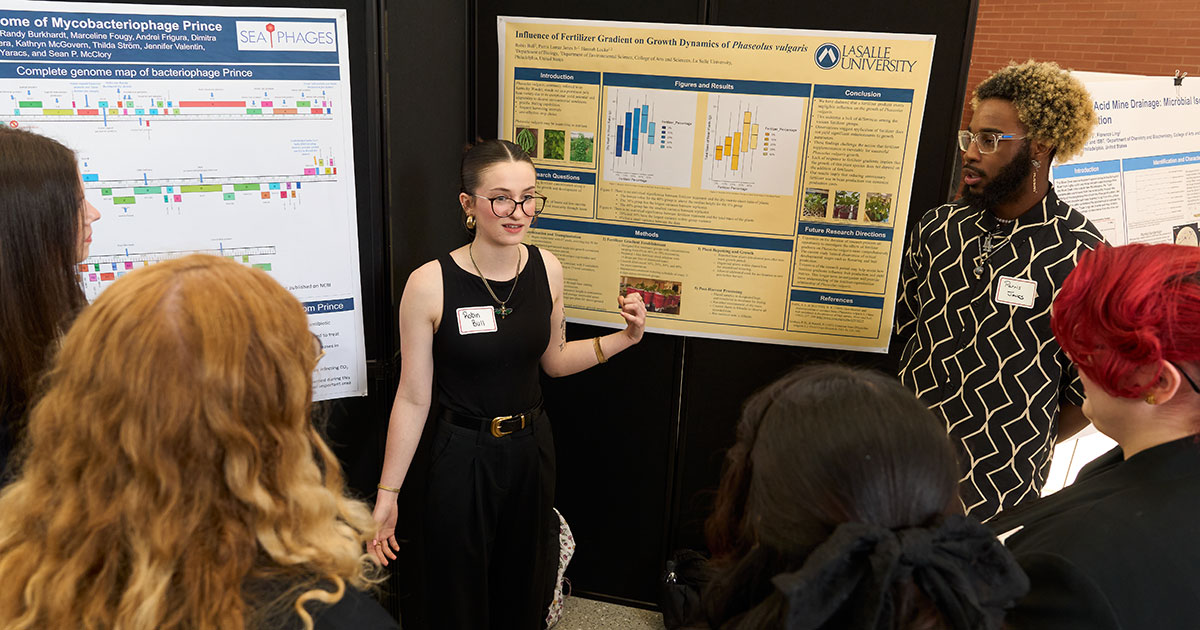 Image of a student presenting her research poster. Image of a student presenting her research poster.