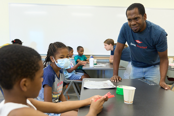 A teacher and two students working on a project.