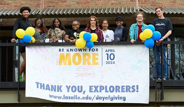 Students pose with Day of Giving banner