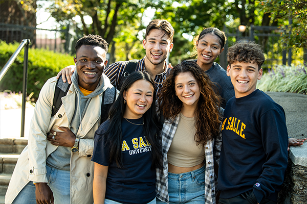 Image of six students posing for a photo with the Hansen Quad in the background.