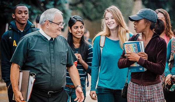 Br. Sheehy walking with a group of students.