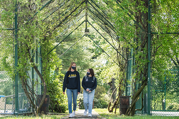Two students walking around La Salle's campus in the Spring.