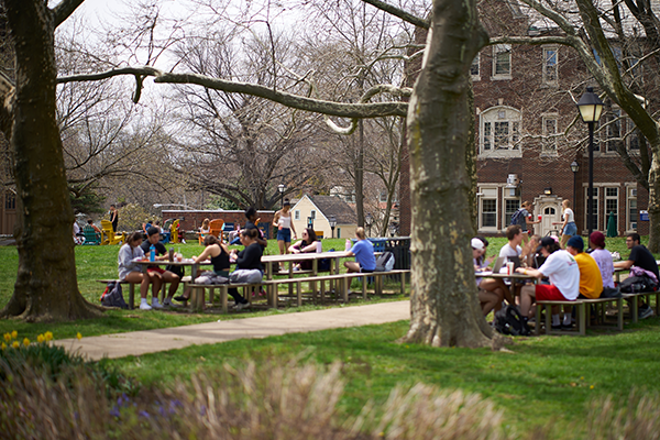 Image of students sitting at the tables on the Hansen Quad.