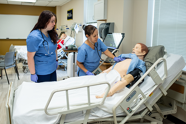 Image of two nurses working in the simulation labs.