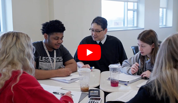 Image of a professor working with students.