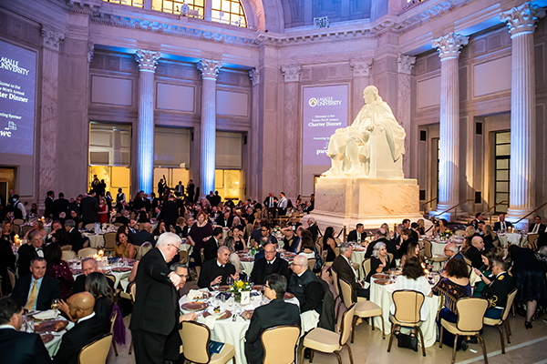 A group of people sitting at tables at the Franklin Institute.