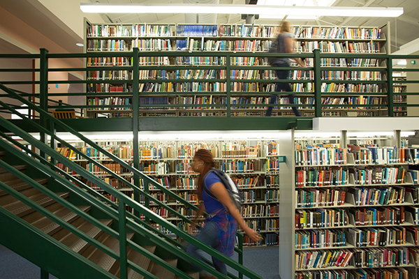 Image of two students walking around the library.