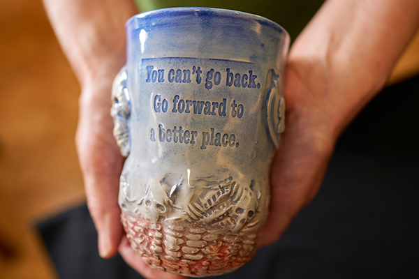 A ceramic cup that says, "You can't go back. Go forward to a better place."