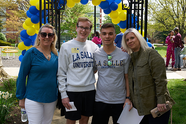 A family posing for a photo on Hansen Quad during College Signing Day.