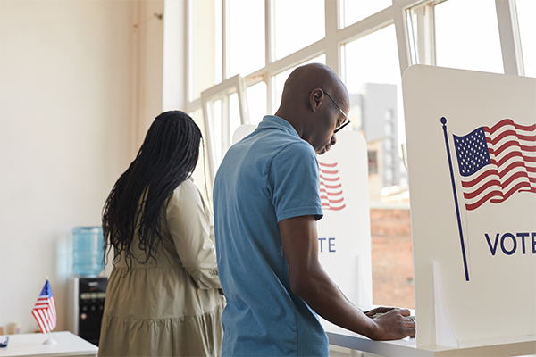 Image of two people voting.