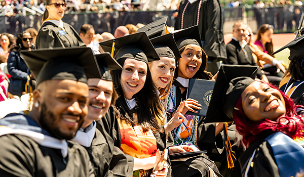 Image of students smiling for a photo at Commencement