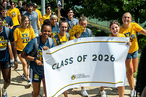 New students holding a "Class of 2026" banner.