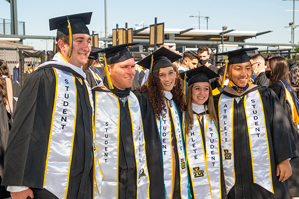 Image of students posing for a photo at graduation.
