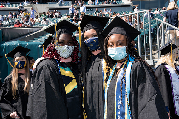 Three students posing for a photo at Commencement.