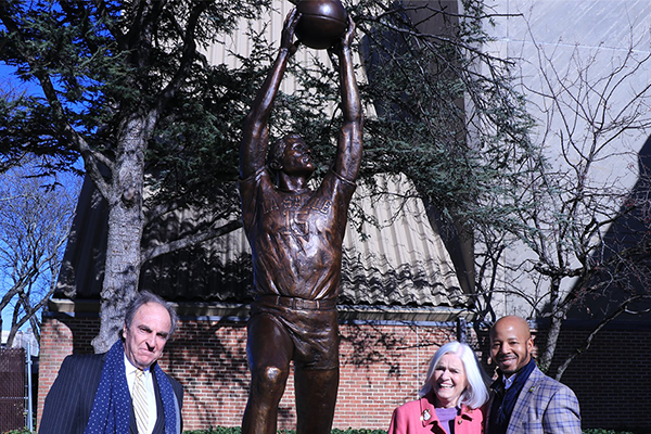 Men’s basketball coach Fran Dunphy, ’70; Caroline Gola; and Vice President of Athletics and Recreation Brian Baptiste unveil an eight-foot statue of Tom Gola, ’55, outside the arena on La Salle’s campus that bears Gola’s name.