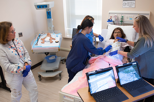 Current La Salle nursing students work closely with faculty members in the sim lab.