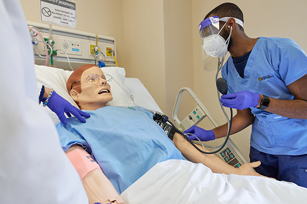 A student and professor working in the nursing simulation lab.