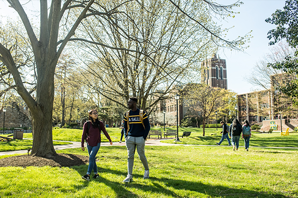 Image of two students walking across campus. 