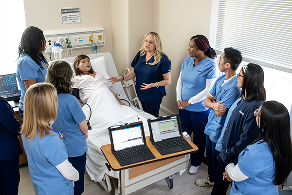 Image of professors and students working in the nursing simulation lab.