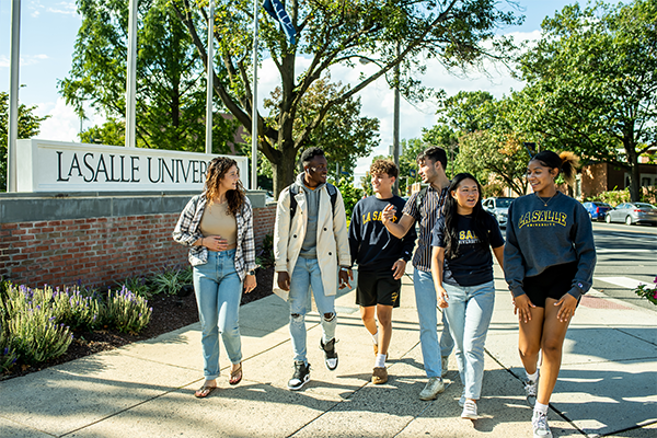 Image of a group of students walking in front of the La Salle monument sign.