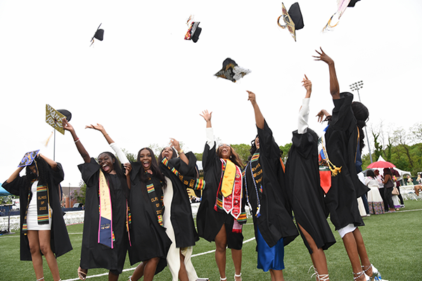 A group of students throwing their graduation caps in the air.