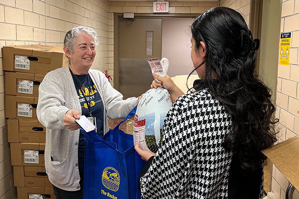 Laura B. Frank, Ph.D., director of La Salle’s campus food pantry The Basket, receives a donation of frozen turkeys and chickens from Philabundance ahead of the Thanksgiving holiday.