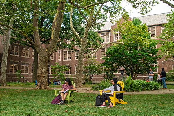 Two students sitting on the Quad.