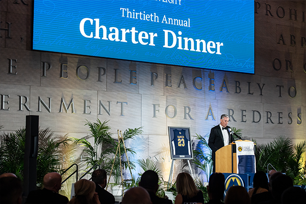 Image of E.F. (Bud) Hansen, III, ’90, MBA ’96, on stage at Charter Dinner.